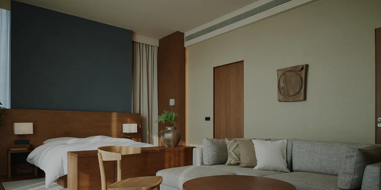 Warm, timber-lined living and sleeping space inside a Two Sudirman residence